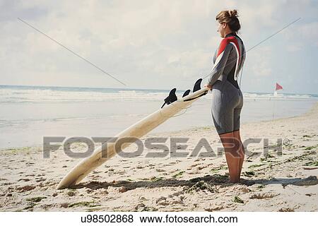 Stock Photo - Surfer with surfboard on beach, Lacanau, France. Fotosearch