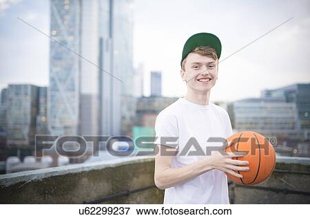 Stock Photo - Teenage boy holding basketball. Fotosearch