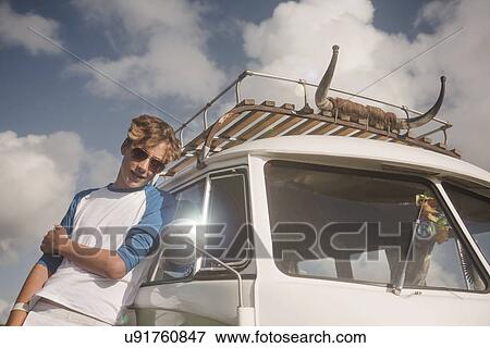 Stock Photo - Teenage boy leaning against car. Fotosearch