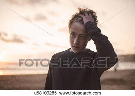 Teenage boy on beach, hand in hair View Large Photo Image Stock Photography - Teenage boy on beach, hand in hair. Fotosearch