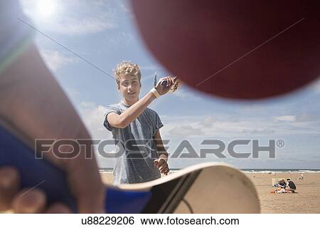 Teenage boy playing bat and ball on beach View Large Photo Image Stock Photograph - Teenage boy playing bat and ball on beach. Fotosearch