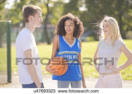 Three young adult basketball players chatting View Large Photo Image Stock Image - Three young adult basketball players chatting. Fotosearch