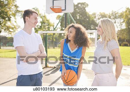 Three young adult basketball players chatting on basketball court View Large Photo Image Stock Image - Three young adult basketball players chatting on basketball court. Fotosearch
