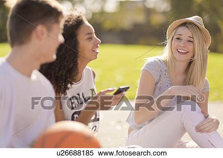 Three young adult basketball players chatting and laughing View Large Photo Image Stock Photography - Three young adult basketball players chatting and laughing. Fotosearch