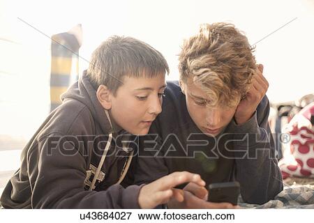 Two boys using smartphone View Large Photo Image Stock Photo - Two boys using smartphone. Fotosearch