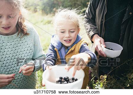 Two girls holding blackberries in bowl View Large Photo Image Stock Photo - Two girls holding blackberries in bowl. Fotosearch