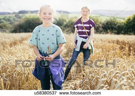 Two girls in field, smiling View Large Photo Image Stock Photo - Two girls in field, smiling. Fotosearch