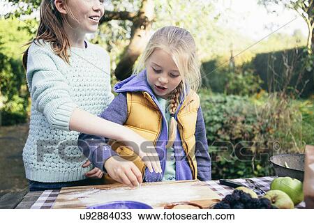 Stock Image - Two girls making food. Fotosearch