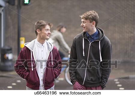 Stock Photograph - Two male friends crossing road. Fotosearch