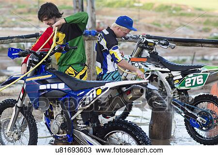 Two male motocross competitors cleaning motorcycles with water hoses View Large Photo Image Stock Image - Two male motocross competitors cleaning motorcycles with water hoses. Fotosearch