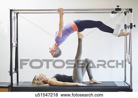Two mature women practicing pilates on trapeze table in pilates gym View Large Photo Image Stock Photo - Two mature women practicing pilates on trapeze table in pilates gym. Fotosearch