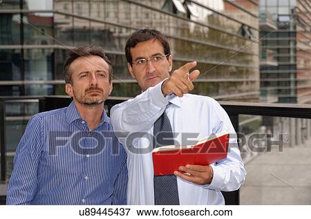 Two men having discussion, pointing and looking ahead View Large Photo Image Stock Photo - Two men having discussion, pointing and looking ahead. Fotosearch