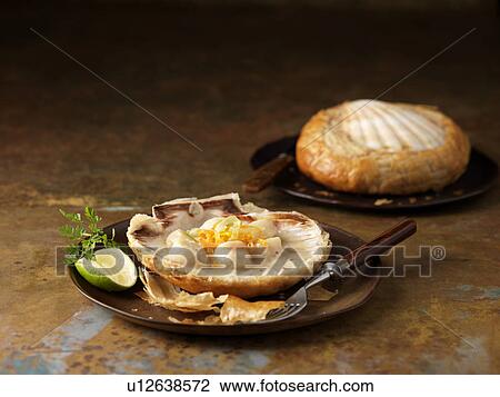 Stock Image - Two scallops baked in shells with vermouth, chervil garnish and lime. Fotosearch