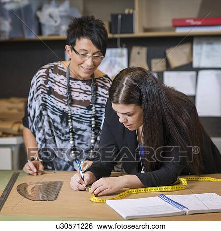 Stock Photograph - Two seamstresses making dressmakers pattern in workshop. Fotosearch