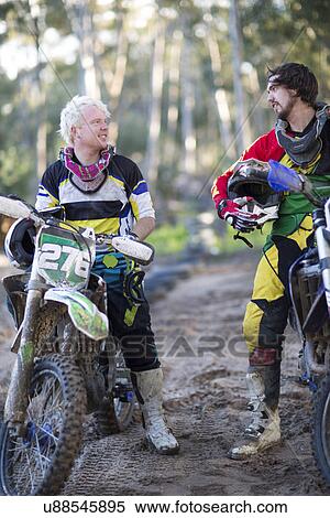 Two young male motocross competitors chatting on forest track View Large Photo Image Stock Photography - Two young male motocross competitors chatting on forest track. Fotosearch