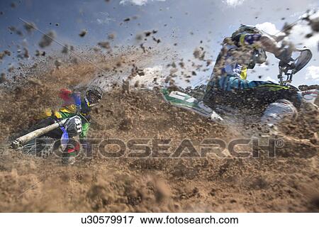 Two young male motocross riders racing through mud View Large Photo Image Stock Photo - Two young male motocross riders racing through mud. Fotosearch