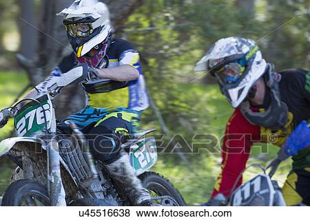 Two young male motocross riders racing through forest View Large Photo Image Stock Photo - Two young male motocross riders racing through forest. Fotosearch