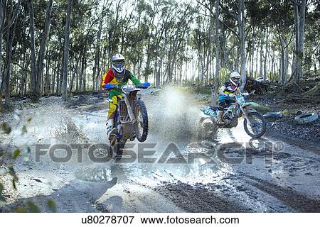 Two young male motocross riders racing on dusty track View Large Photo Image Stock Photo - Two young male motocross riders racing on dusty track. Fotosearch