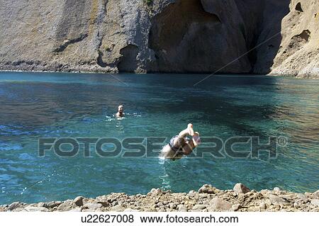 Two young men diving into sea and swimming, Marseille, France View Large Photo Image Stock Photo - Two young men diving into sea and swimming, Marseille, France. Fotosearch