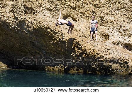 Two young men diving into sea from rocks, Marseille, France View Large Photo Image Stock Photo - Two young men diving into sea from rocks, Marseille, France. Fotosearch