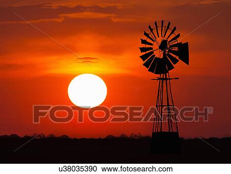 Stock Image - Windmill at sunset, Namibia. Fotosearch