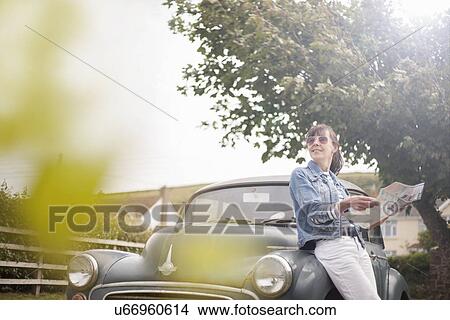 Woman leaning against vintage car View Large Photo Image Picture - Woman leaning against vintage car. Fotosearch