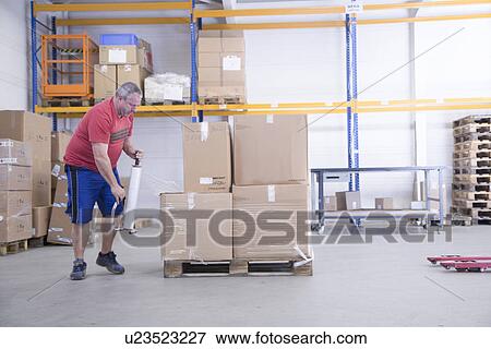 Stock Photo - Worker packing at healthcare warehouse. Fotosearch