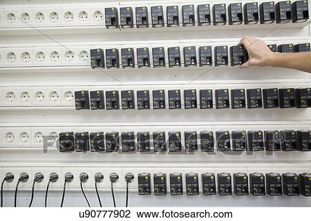 Stock Image - Worker testing chargers at healthcare warehouse. Fotosearch