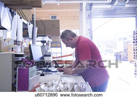 Worker writing notes at healthcare warehouse View Large Photo Image Stock Image - Worker writing notes at healthcare warehouse. Fotosearch