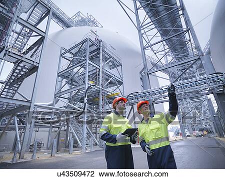 Workers in discussion in biomass facility, low angle view View Large Photo Image Stock Image - Workers in discussion in biomass facility, low angle view. Fotosearch