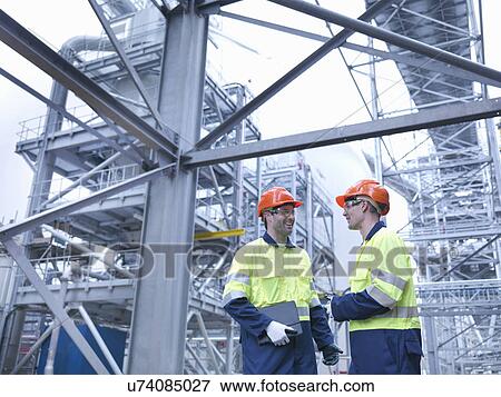 Stock Photo - Workers in discussion in biomass facility. Fotosearch