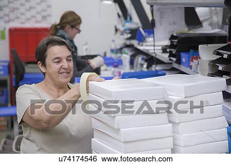 Stock Photograph - Workers packing at healthcare warehouse. Fotosearch