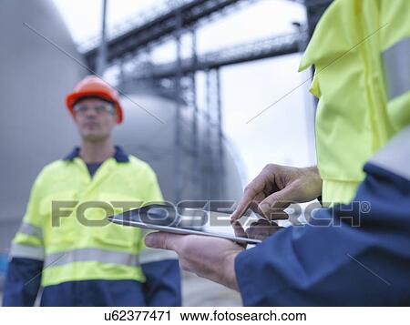 Workers using digital tablet at biomass facility, close up View Large Photo Image Stock Image - Workers using digital tablet at biomass facility, close up. Fotosearch