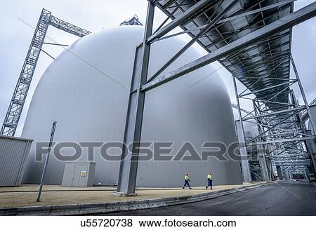 Stock Photo - Workers walking through biomass facility, low angle view. Fotosearch