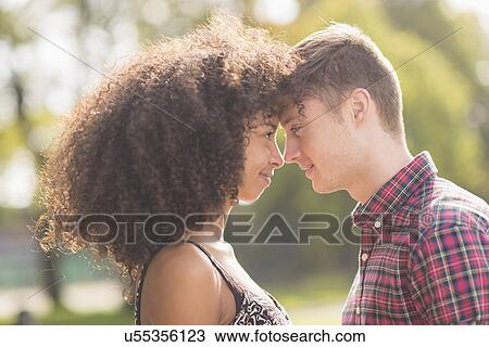 Stock Image - Young couple face to face in park. Fotosearch