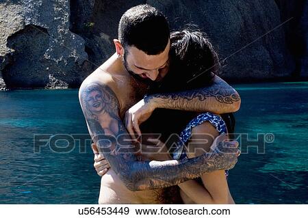 Stock Photo - Young couple hugging at coast, Marseille, France. Fotosearch