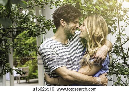 Young couple hugging in garden View Large Photo Image Stock Image - Young couple hugging in garden. Fotosearch