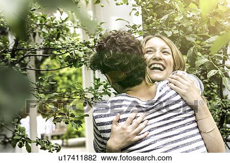 Young couple hugging in garden View Large Photo Image Stock Image - Young couple hugging in garden. Fotosearch