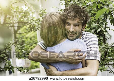 Young couple hugging in garden View Large Photo Image Stock Photograph - Young couple hugging in garden. Fotosearch