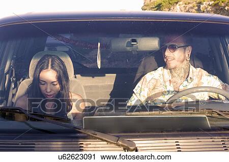 Stock Image - Young couple in car on road trip. Fotosearch