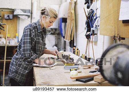 Young craftswoman making notes at workbench in pipe organ workshop View Large Photo Image Stock Photo - Young craftswoman making notes at workbench in pipe organ workshop. Fotosearch