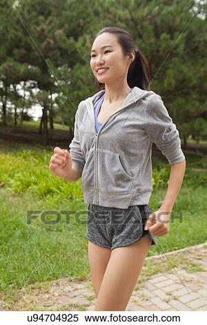 Stock Photography - Young female runner running in park. Fotosearch