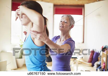 Young female student and tutor in pilates gym View Large Photo Image Stock Image - Young female student and tutor in pilates gym. Fotosearch