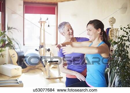 Picture - Young female student practicing with tutor in pilates gym. Fotosearch