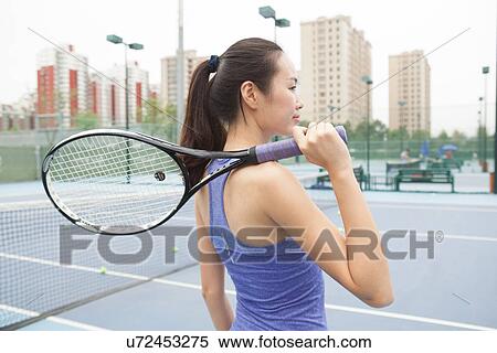 Young female tennis player with tennis racket on shoulder on tennis court View Large Photo Image Stock Photography - Young female tennis player with tennis racket on shoulder on tennis court. Fotosearch