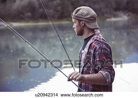 Picture - Young fisherman fishing in lake, Premosello, Verbania, Piemonte, Italy. Fotosearch