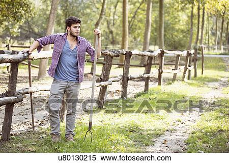 Young male farmer leaning against paddock fence, Premosello, Verbania, Piemonte, Italy View Large Photo Image Stock Photography - Young male farmer leaning against paddock fence, Premosello, Verbania, Piemonte, Italy. Fotosearch