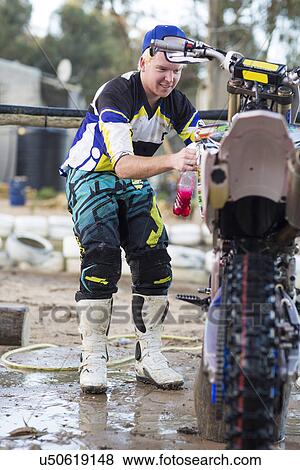 Young male motocross competitor cleaning motorcycle View Large Photo Image Stock Photo - Young male motocross competitor cleaning motorcycle. Fotosearch