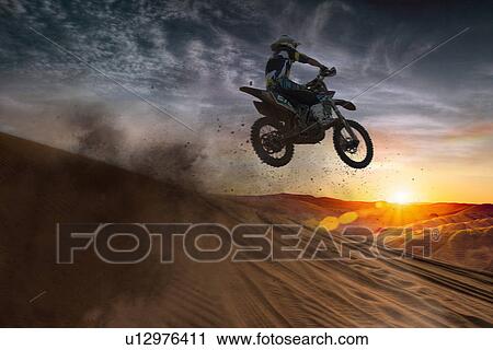 Young male motocross racer jumping mid air at sunset View Large Photo Image Stock Image - Young male motocross racer jumping mid air at sunset. Fotosearch