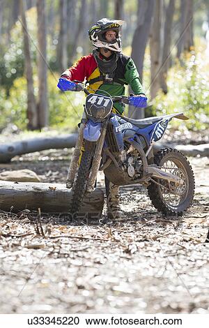 Young male motocross racer standing in forest View Large Photo Image Stock Image - Young male motocross racer standing in forest. Fotosearch